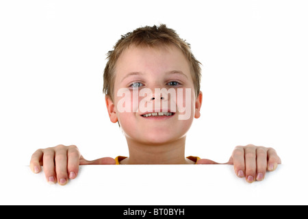 Small boy looking out of a blank whiteboard smiling isolated on white Stock Photo