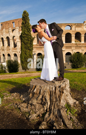 Newlyweds kissing in front of the Roman Colosseum Stock Photo