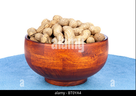 A cherry wood bowl of shelled peanuts on a white background. Stock Photo