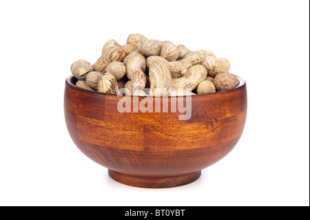 A cherry wood bowl of shelled peanuts on a white background. Stock Photo