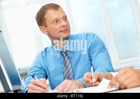 Portrait of a businessman sitting at table and looking away Stock Photo