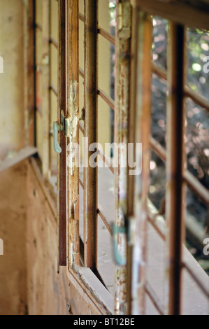 Rusty window frame in decaying house. Selective focus. Stock Photo