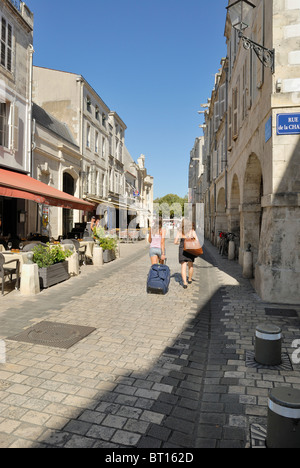 Women walking down a cobblestone street in the historic town of La Rochelle Charente-Maritime France Stock Photo