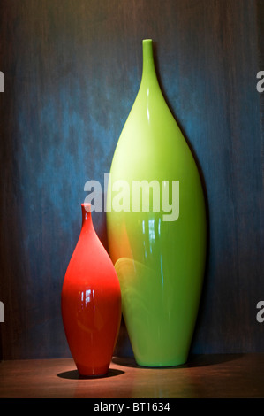 Two colorful ceramic vases sitting on shelf in hotel display Stock Photo