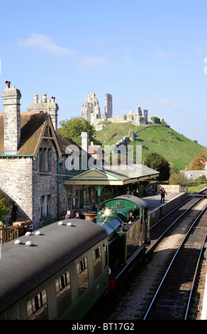 steam train at corfe station corfe castle in background on the preserved swanage railway line Stock Photo
