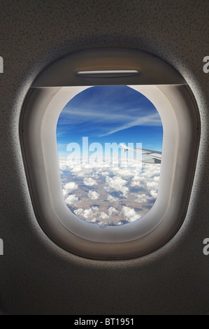 cloudscape seen through an airplane window from the passenger seat Stock Photo