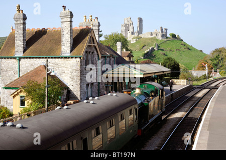 steam train at corfe station castle behind on the preserved swanage railway line Stock Photo