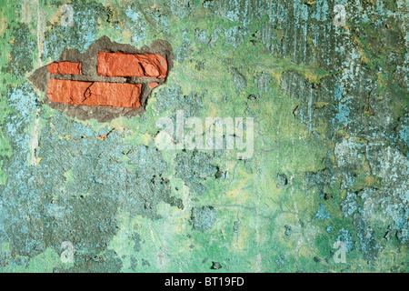Damaged painted old brick wall with hole Stock Photo