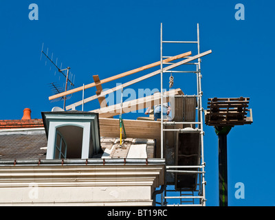 Contractors working on roof repairs with Altrad prefabricated scaffolding units / no safety equipment - France. Stock Photo