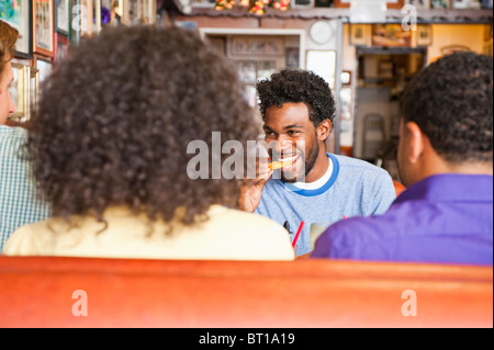 Smiling friends eating in diner booth Stock Photo