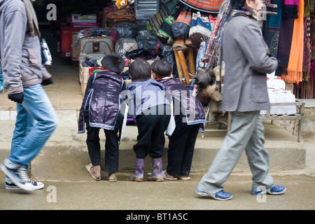 Three curious Black hmong boys try to watch tv in a shop form the street Stock Photo