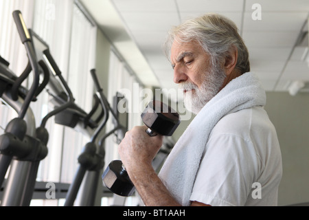 Physically fit and health conscious senior man working out with dumbbell in gym, October 13, 2010 Stock Photo