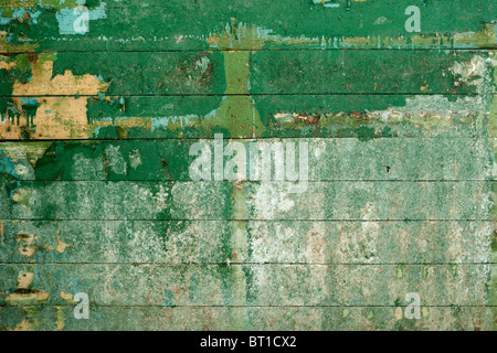 Green surface of the old, semidecayed wall covered with boards Stock Photo