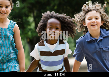 Children holding hands and running in park, laughing Stock Photo - Alamy