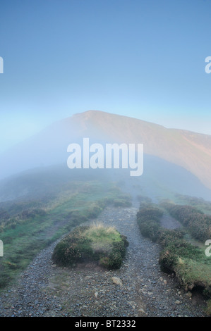 Footpath through the mist to the summit of Grisedale Pike in the English Lake District Stock Photo