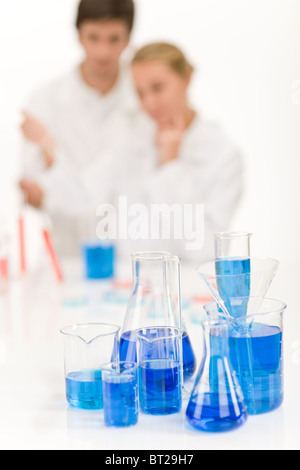 Scientists in laboratory - blue liquid in beakers Stock Photo