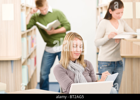High school library - female student with laptop and book Stock Photo