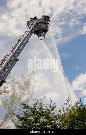 Firefighters training from ladder on ladder truck, with hoses, New Haven, Connecticut, USA Stock Photo