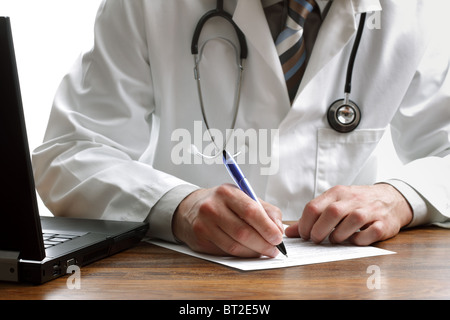 Doctor writing a prescription or medical examination notes Stock Photo