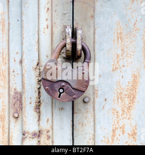 Rusty old padlock on a metal fence Stock Photo