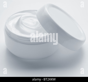 Opened plastic container with cream on a white background. Stock Photo