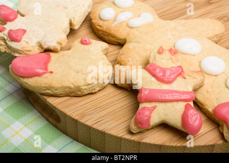 Gingerbread biscuits decorated by child on wooden board from low perspective. Stock Photo