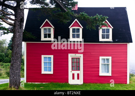 Traditional red painted cottage on Newfoundland coast, Canada Stock Photo