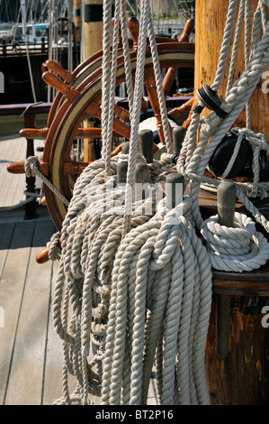 Steering wheel and ropes coiled around belaying pins aboard the Grand Turk, a three-masted frigate at Saint Malo, Brittany Stock Photo