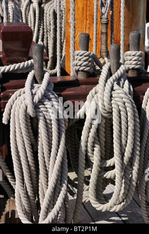 Ropes coiled around belaying pins of the Grand Turk / Etoile du Roy, a three-masted frigate at Saint Malo, Brittany, France Stock Photo