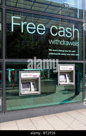 Free Cash slogan above atm cash machines also showing split height levels for disabled wheelchair users outside London bank Stock Photo