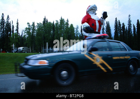 North Pole Police squad car passing by a large Santa Claus statue, Alaska, USA Stock Photo