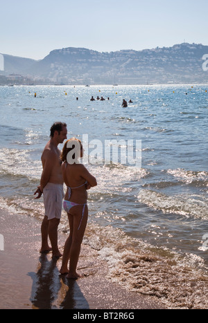 Couple at water's edge Playa de Roses beach Emporda Catalunya Spain Stock Photo