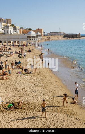 Tourists enjoy themselves on the sandy Spanish beach at Cadiz. Spain. Stock Photo