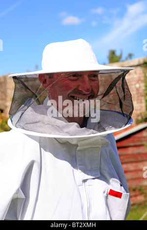 Adult man wearing a full head to toe protective suit at a Honey Bee farm in Dorset Stock Photo