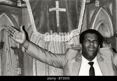 Visiting minister Rev Winston Willis leading congregation in prayer in the New Testament Church of God Newport South Wales UK Stock Photo