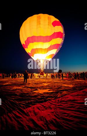 Hot air balloon lit at dawn with American Flag tarp in foreground at the Albuquerque International Balloon Fiesta. Stock Photo