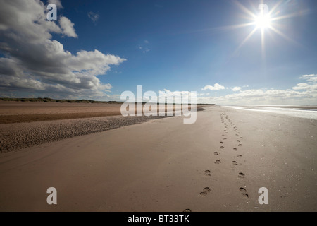 A trail of footprints in the sand along Ainsdale Beach, Southport. It is situated on the Sefton Coast, UK and is a very popular recreational beach. Stock Photo