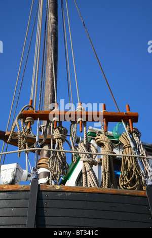Old sailing ship and fishing vessel with coiled rope and various vintage equipment on the mast and rig Stock Photo