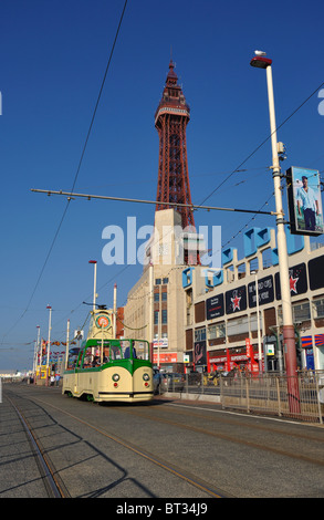 A tram passes under Blackpool Tower on the sea front Stock Photo