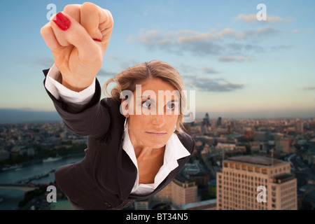 Super businesswoman flying over London city Stock Photo