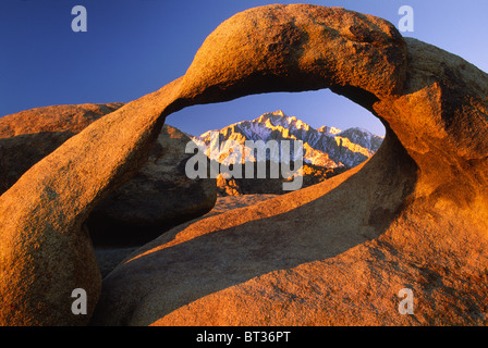 Granite arch in California's Alabama Hills with the Sierra Nevada range in the distance Stock Photo