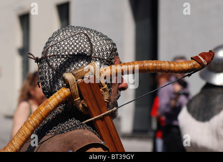 Man dressed as medieval crossbow man in costumed procession Stock Photo