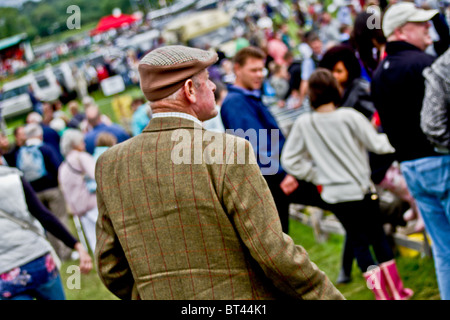back view of country gentleman in crowd at field event Stock Photo