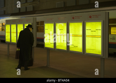 A man checks the schedule while waiting for a train at Antwerp Central Station in Antwerp, Belgium. Stock Photo