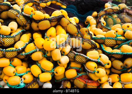 Closeup on fishing net with yellow floaters stored on fisher boat during the day Stock Photo