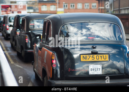 Taxis wait in a taxi rank outside London Waterloo station  in London, England. Stock Photo