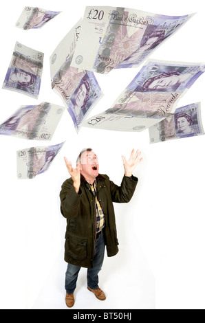 Man looking up to catch floating or falling £20 notes Stock Photo