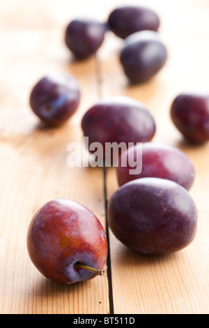 fresh plums on wooden table Stock Photo