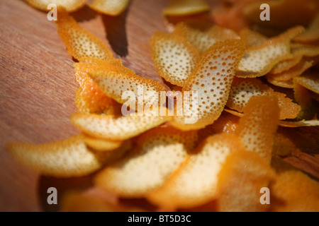 Layers of orange peel on a wooden chopping board. Stock Photo