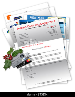 Collection agency letter with household bills beneath, credit cards and Christmas holly on top Stock Photo